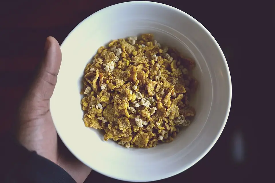 Un bol de céréales de petit-déjeuner avec du lait, vu de dessus sur une table claire